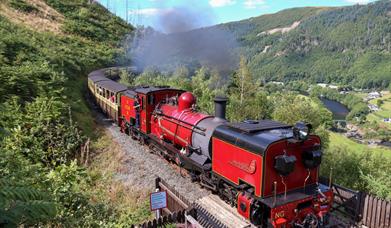 A red engine no.60 'Drakensberg' steaming above the Rheidol Valley
