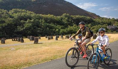 Family on bikes in front of dam wall at Elan Valley