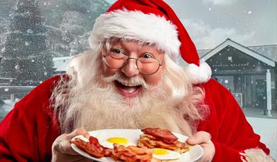 Santa holding plate of bacon and eggs with Elan Valley Visitor Centre in background