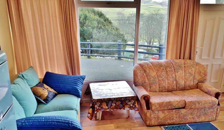 Sea Moss Cabin is Open Plan. The sun streams through this window in the morning and early afternoon to make this seating area a sunny "room with a vie