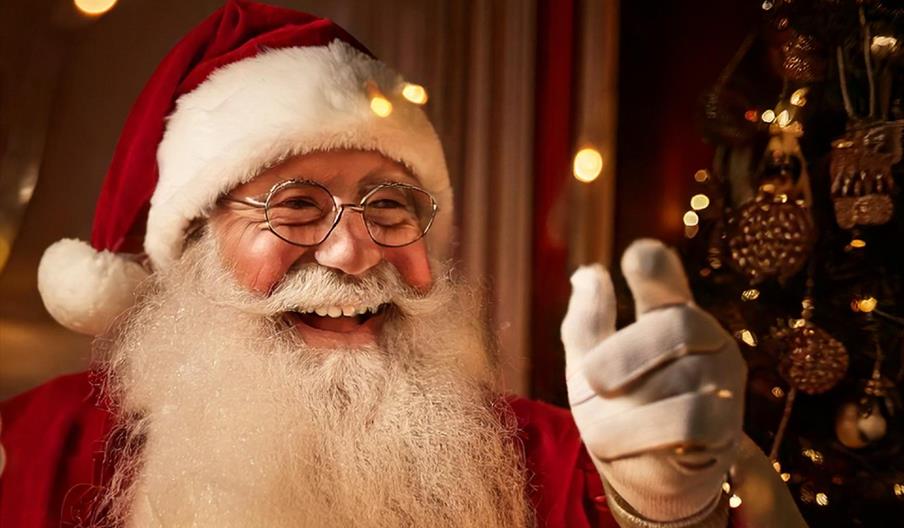 Santa with fairy lights in background