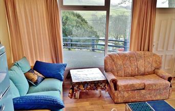 Sea Moss Cabin is Open Plan. The sun streams through this window in the morning and early afternoon to make this seating area a sunny "room with a vie