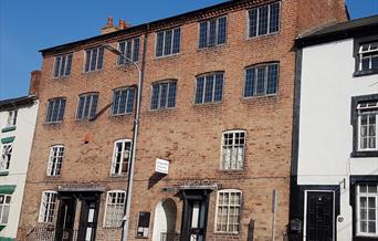 The building was originally six two-room cottages with 2 loom floors above. Each window had a loom. Now the cottages relate the woollen industry story