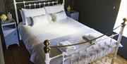 King sized bed with white linen and towels