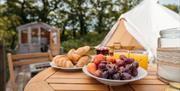 Breakfast table with view of glamping in the distance