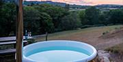 The view of the valley at sunset with a wood fire hot tub in the foreground