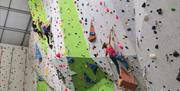 Three experienced climbers lead climb high up on the walls.