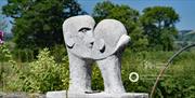 Kissing sculpture with Arts Council Of Wales member logo.