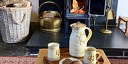 Coffee pot and cups in front of log burner at Drovers Retreat