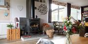 Lounge at Hafren Forest Hideaway with lit wood burner, cosy group accommodation in Mid Wales