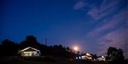 Three safari tents nestled into the hillside at night