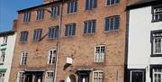 The building was originally six two-room cottages with 2 loom floors above. Each window had a loom. Now the cottages relate the woollen industry story