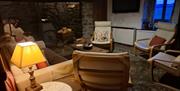 Rustic lounge wth large fireplace and log burner