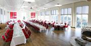 Medrus Mawr Conference Room set up with rows of tables set up for a formal dinner.