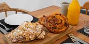 A close up of pastries and a table laid for breakfast