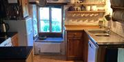 Cottage kitchen, with cooker, sink, dishwasher.